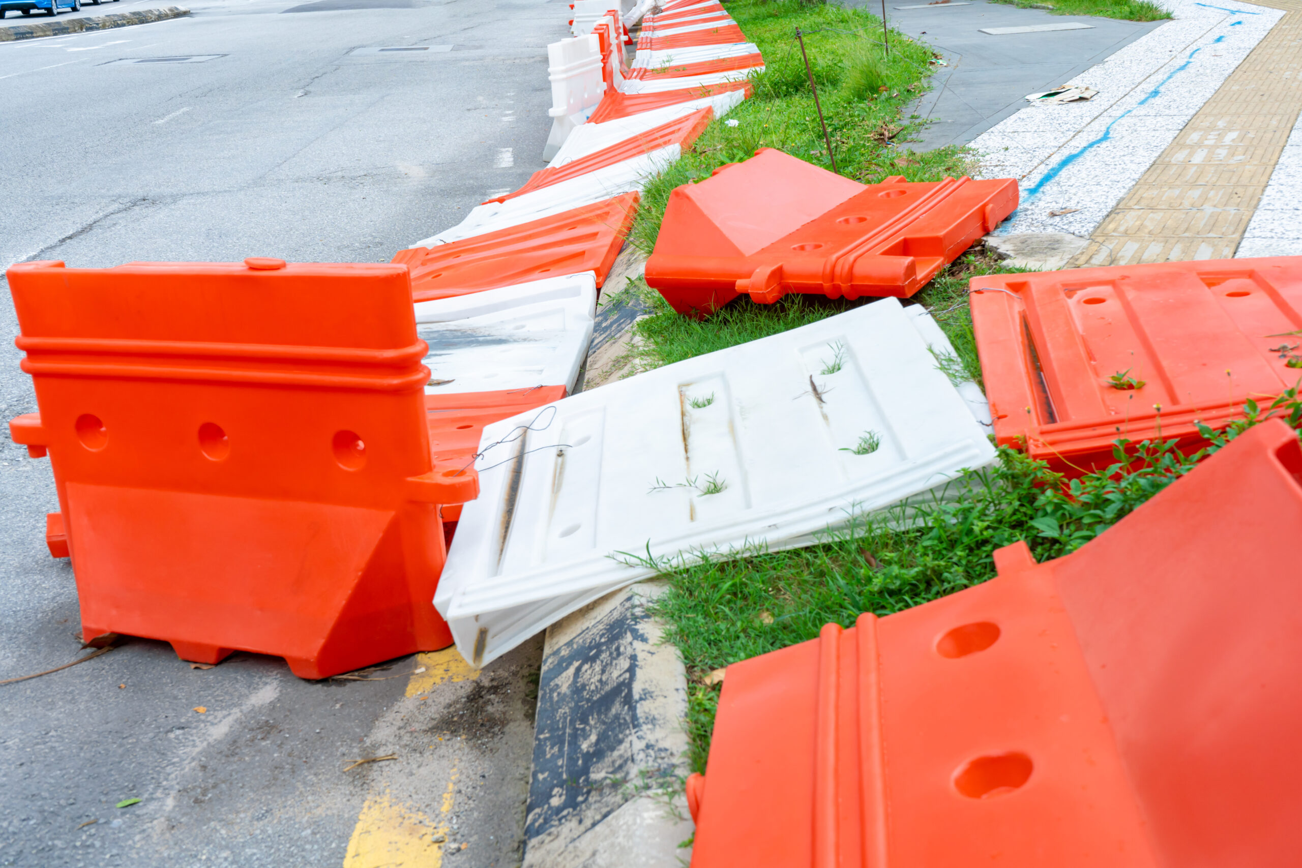 Plastic blocks restricting the passage of cars during repair work. Safe Plastic Road Fences.