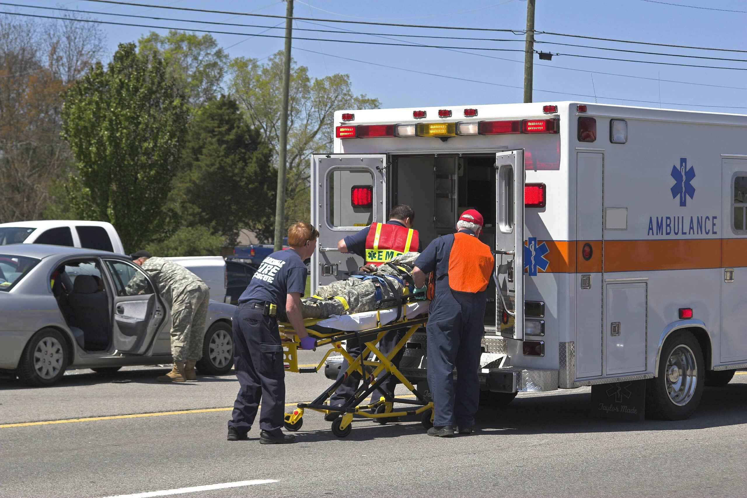 a patient is loaded into an ambulance