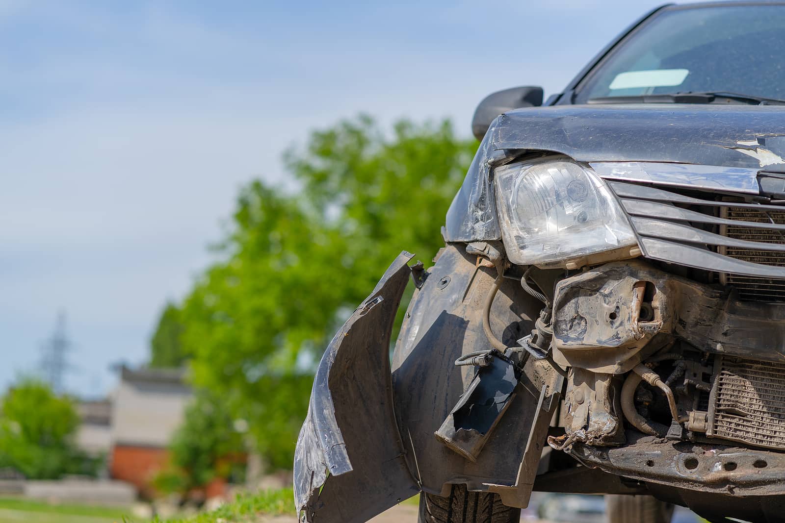 The car after the accident. Broken car on the road. The body of the car is damaged as a result of an accident. High speed head on a car traffic accident. Dents on the car body after a collision on the highway