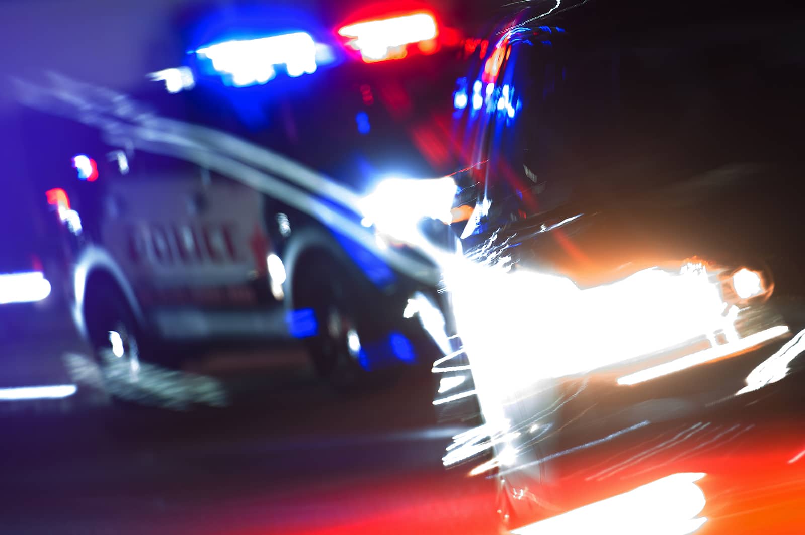 blurred police lights flashing behind car as police investigate a DUI crash in Las Vegas, Nevada