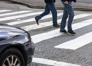 las vegas residents walking through a crosswalk as a car approaches intersection
