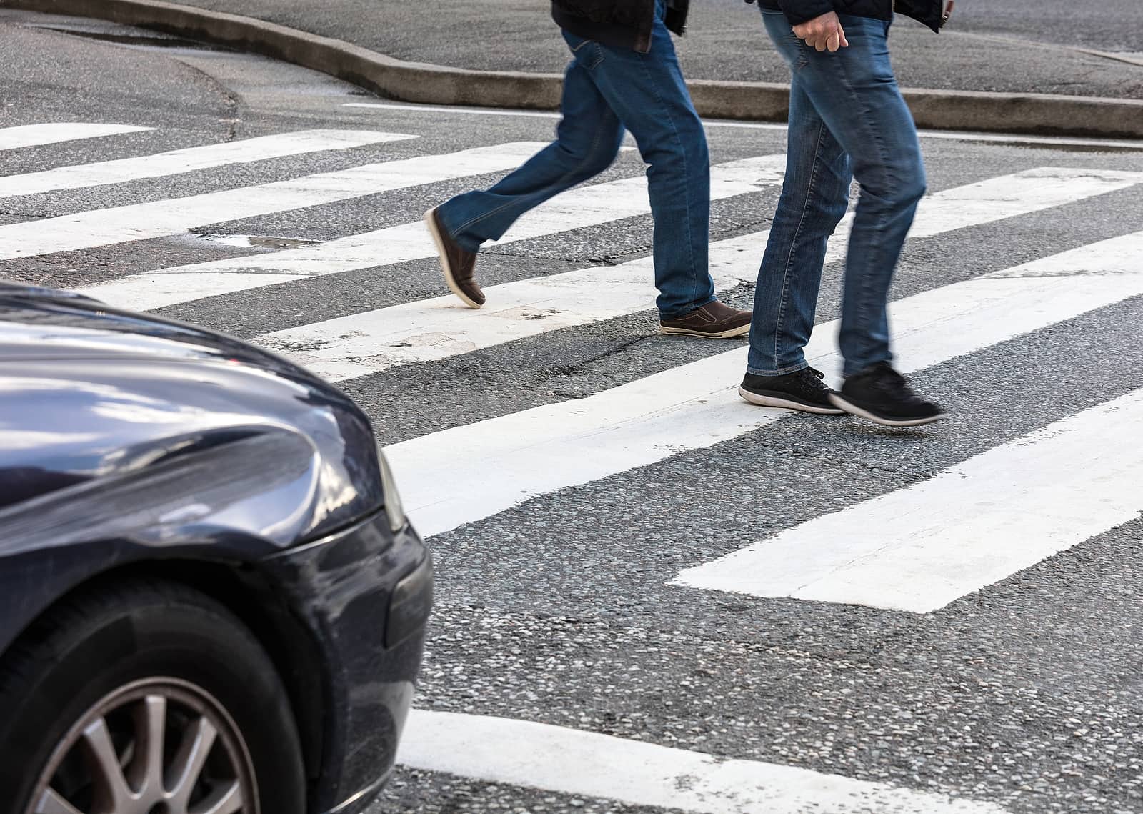 las vegas residents walking through a crosswalk as a car approaches intersection