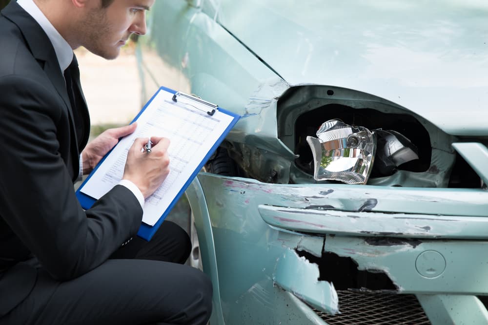 Insurance company representative surveying car after accident in Las Vegas Nevada