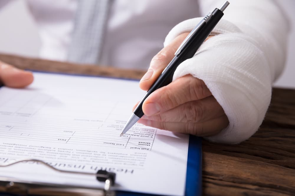 A personal injury victim signing insurance claim papers